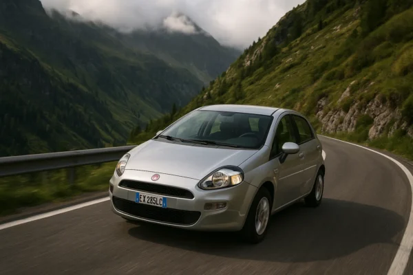 Todo lo que debes saber para elegir el mejor seguro de coche para Fiat Punto Fiat Punto circulando por una carretera de montaña